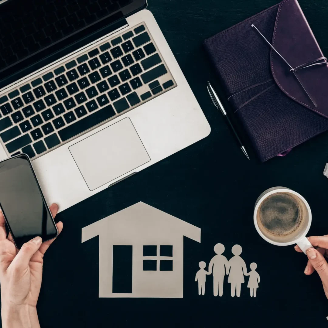 cropped shot of family lawyer using smartphone at workplace with house and family cut out figures